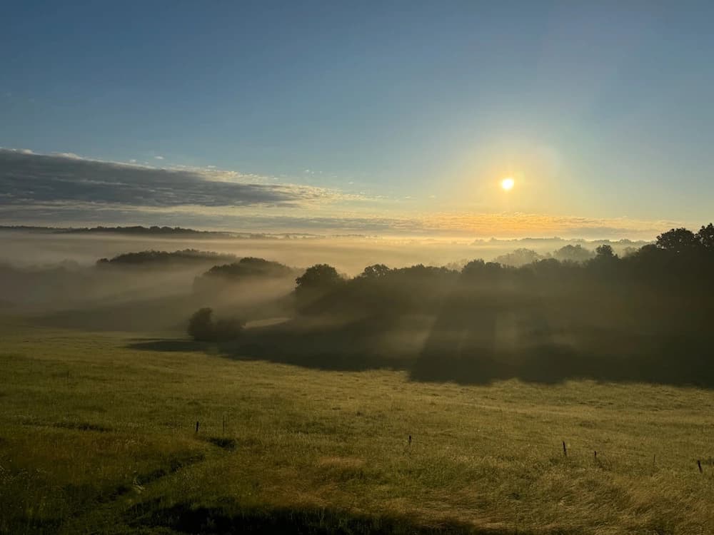 Lever de soleil dans la brume sur les collines voisines