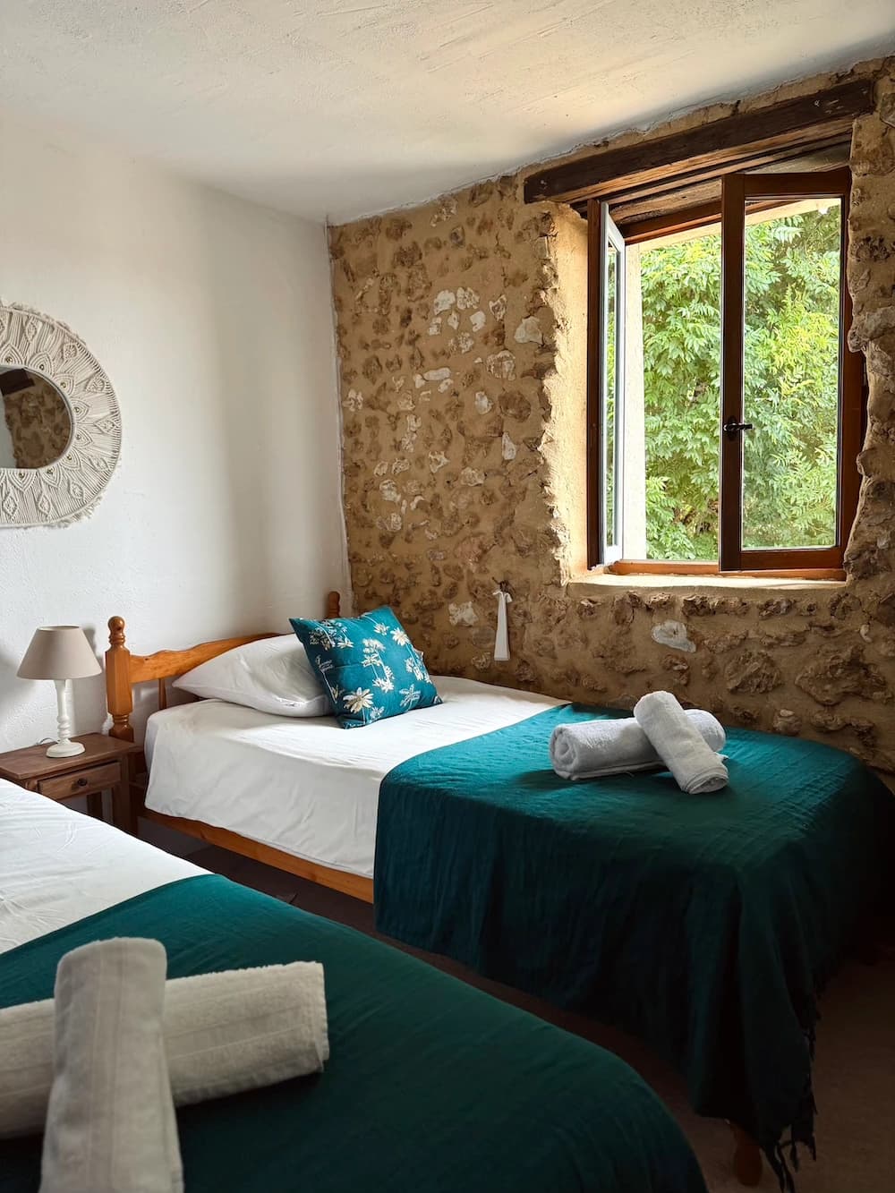 Miroir blanc ajouré au-dessus du lit, coussins blancs