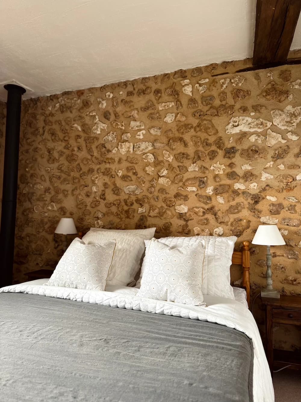 Lit double et lampes de chevet, pierres apparentes